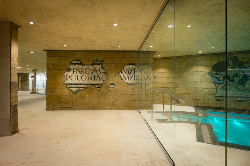 A large glass wall leading to mineral pools, creating a bright and inviting atmosphere.